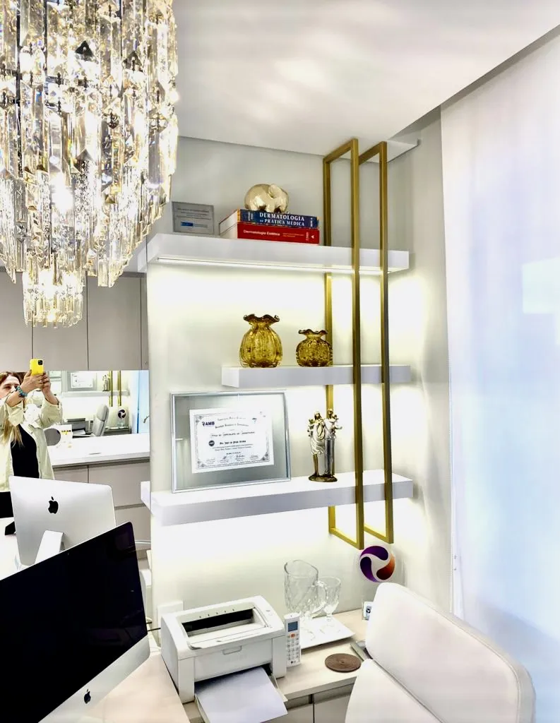 Consultório com estante iluminada e lustre de cristal