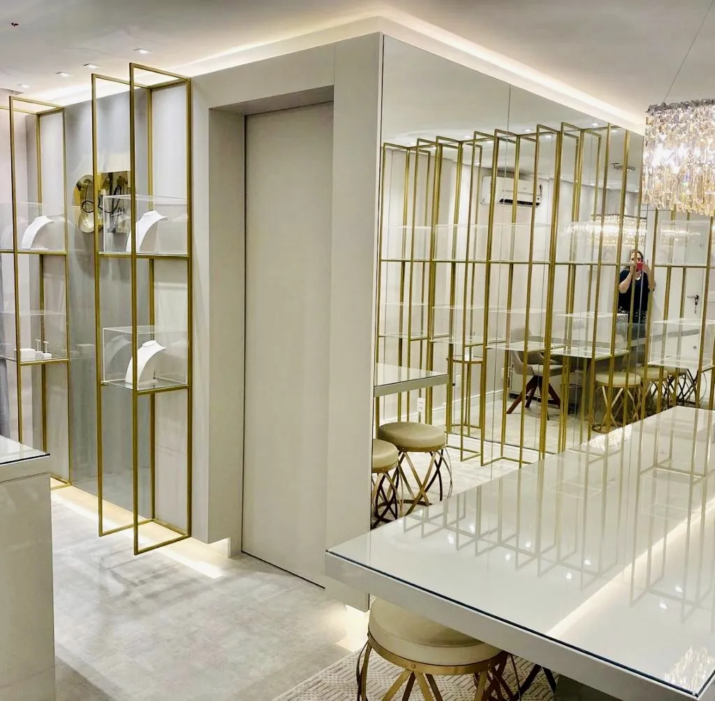 Recepção corporativa com divisórias em metal dourado