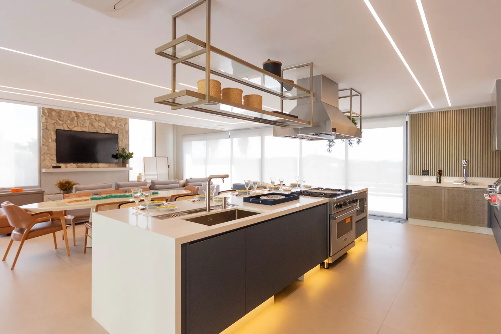 Cozinha gourmet integrada com ilha e iluminação em LED
